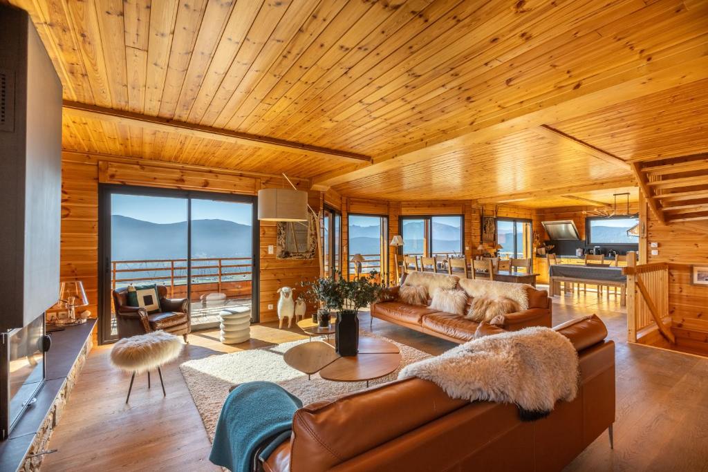un soggiorno con mobili in pelle e soffitto in legno di Chalet des Jonquilles - Magnifique maison avec piscine a Les Angles