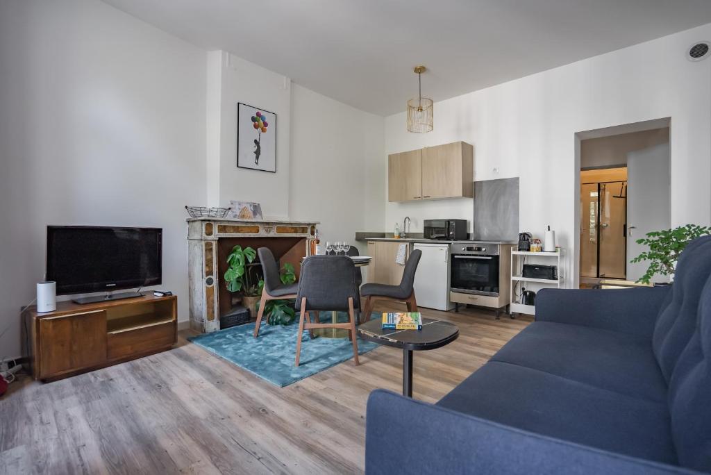 a living room with a blue couch and a kitchen at Le balcon du roi René in Avignon
