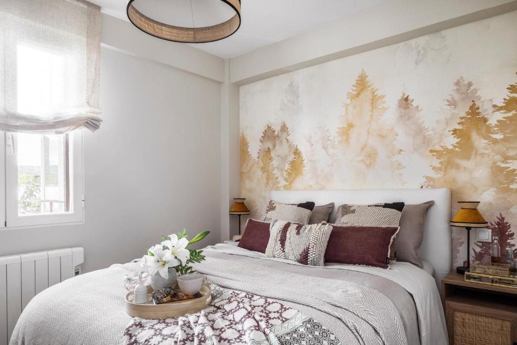 a bedroom with a large white bed with flowers on it at Beachside San Martin de Valdeiglecias in San Martín de Valdeiglesias