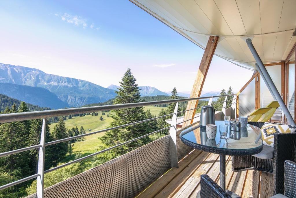 d'un balcon avec une table, des chaises et des montagnes. dans l'établissement Le Machu - Appt 3 vue montagne, à Chamrousse