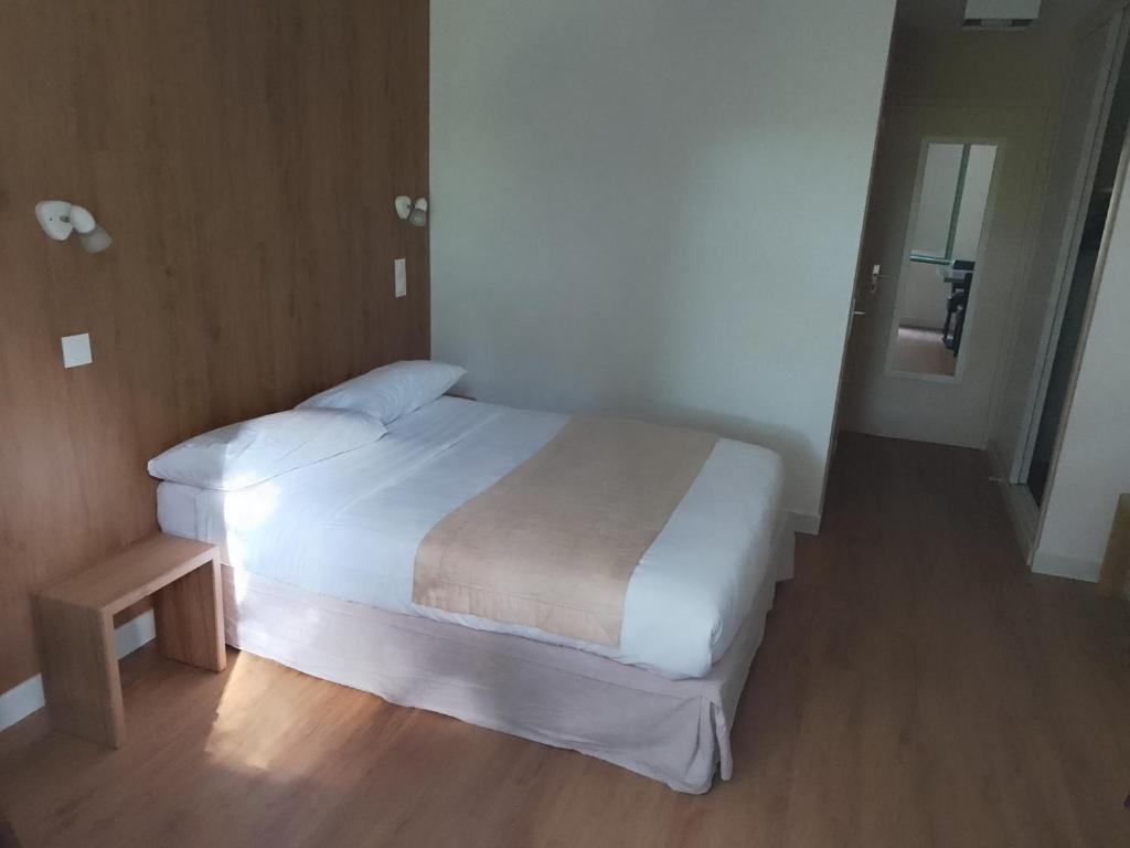 een slaapkamer met een wit bed en een houten vloer bij Chez Yves , 200 m du canal , 7 min de Golfech , parking privé et gratuit , rangement vélo fermés in Pommevic