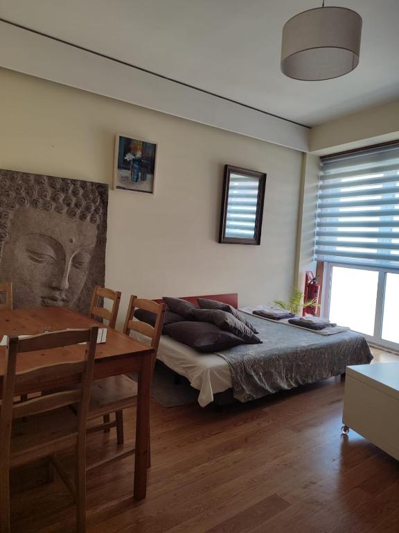a bedroom with a bed and a table and a dining room at VRS - PORTO BEACH FLAT in Porto