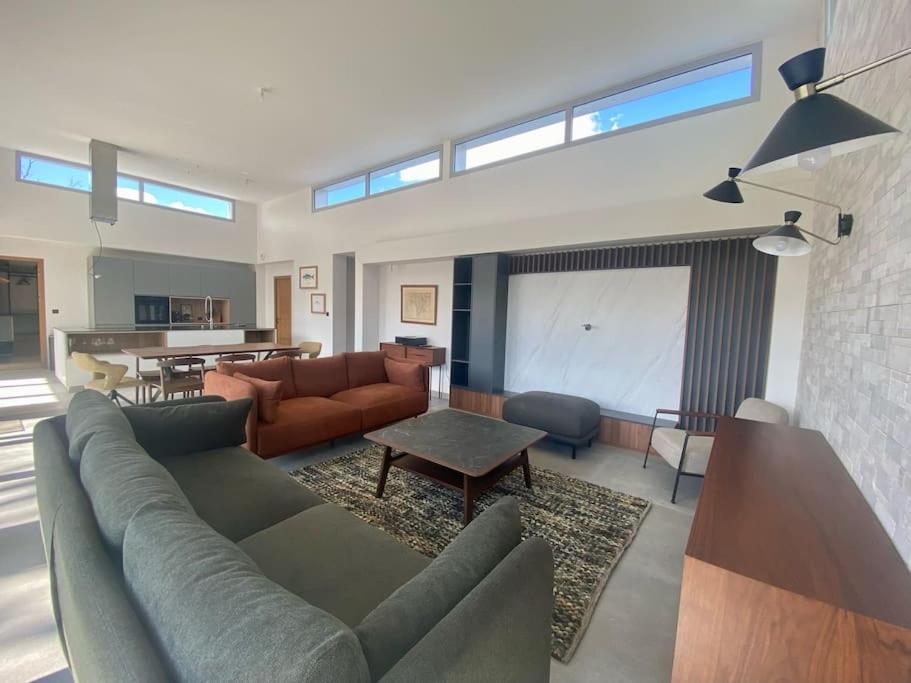 un salon avec un canapé et une table dans l'établissement Villa Romane Piscine Proche Circuit 24h, à Brette-les-Pins