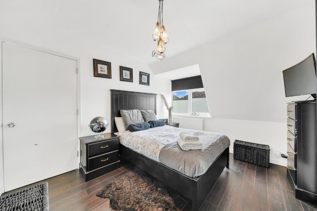 a bedroom with a large bed and a television at Dartford Town 3 Bed by Harlington in Dartford