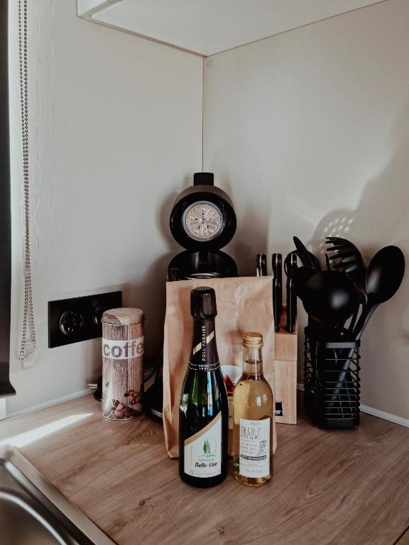 two bottles of wine sitting on a counter with a clock at Super Cordelia - Camping Belle-Vue in Berdorf