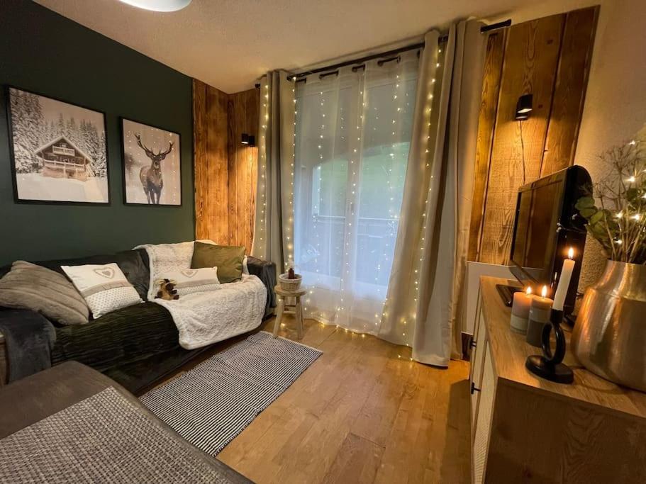 - un salon avec un canapé et une fenêtre éclairée dans l'établissement Studio au pied des pistes, à La Morte