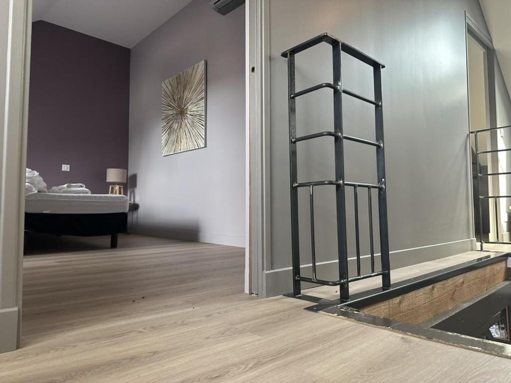 a room with a bedroom with a bed and a ladder at La Maison du Chablisien in Chablis