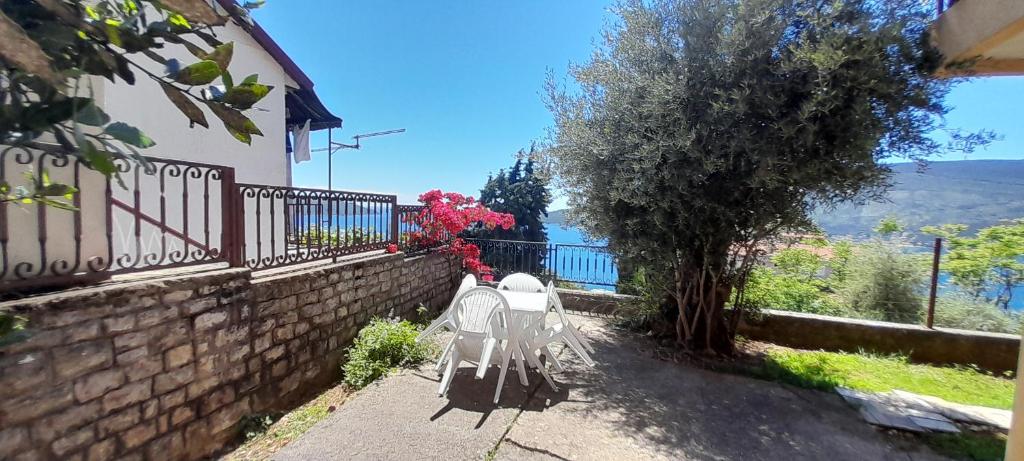 a white bench sitting next to a brick wall at Vake in Herceg-Novi