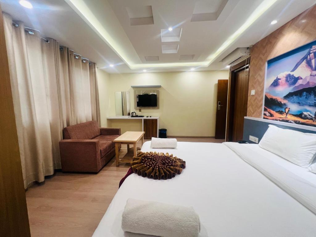 Una habitación de hotel con una cama y una sala de estar. en Hotel Nirakar, en Katmandú