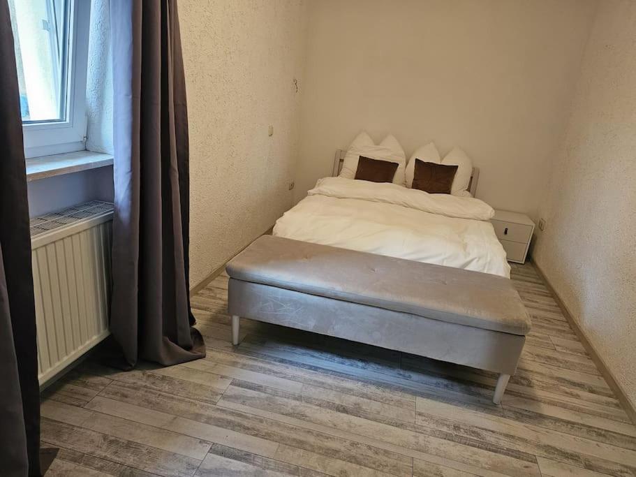 a bed sitting in a room with a window at River Side - 5 min to Grafenwöhr in Pressath