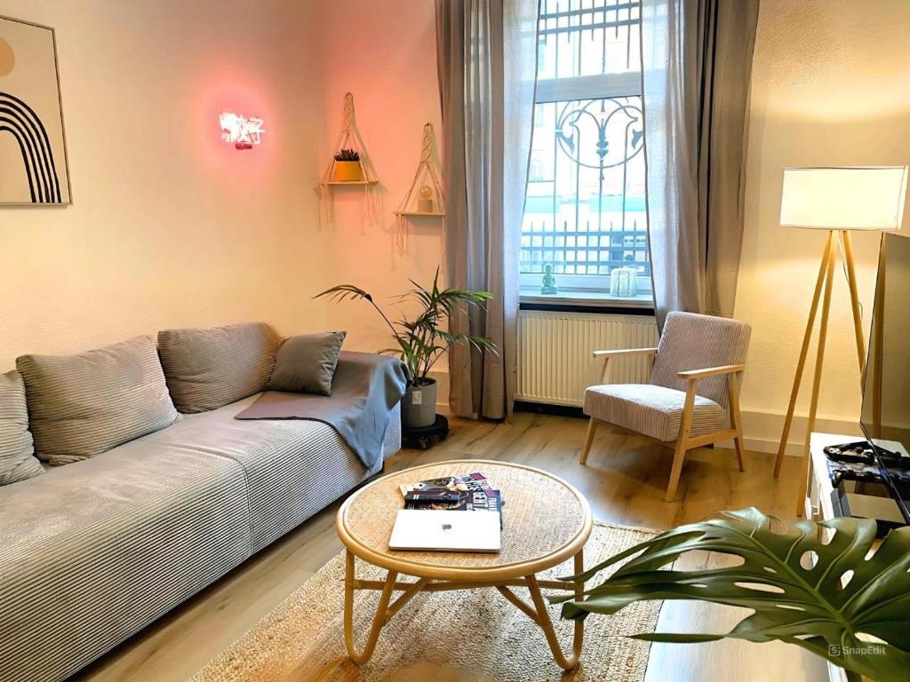 a living room with a couch and a table at Cozy City Oasis Central & Near Fairgrounds in Frankfurt/Main