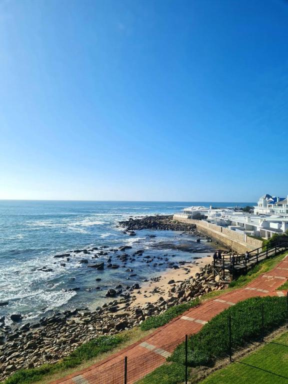 a view of a beach with rocks and the ocean at Point Village Accommodation - Galathea 6 in Mossel Bay