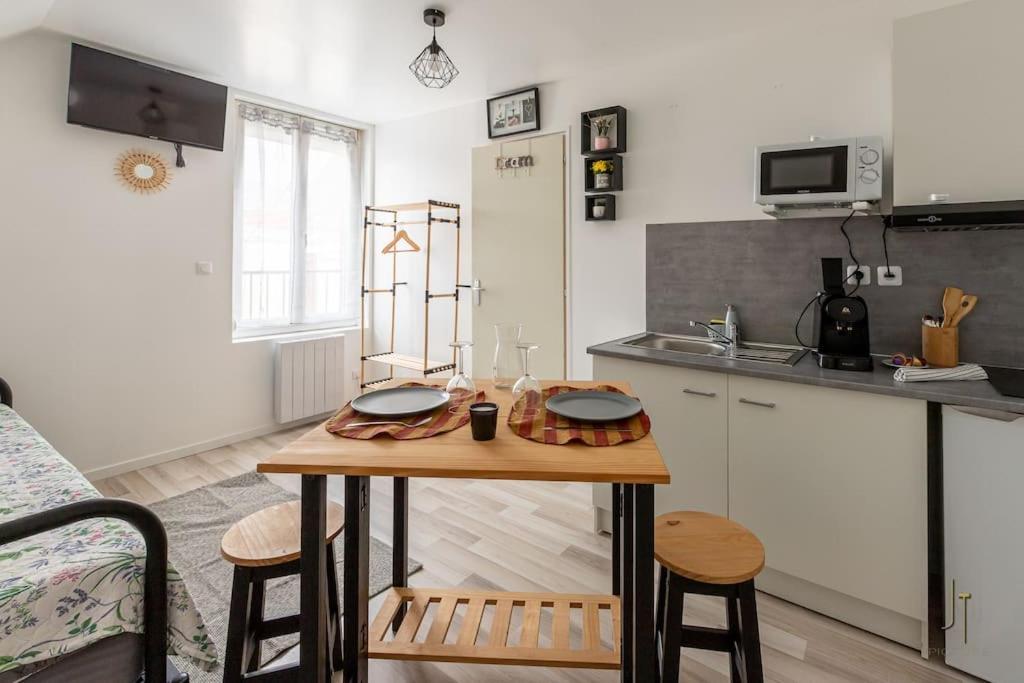 - une cuisine avec une table en bois dans une chambre dans l'établissement Confortable studio tout confort, à Saint-Quentin