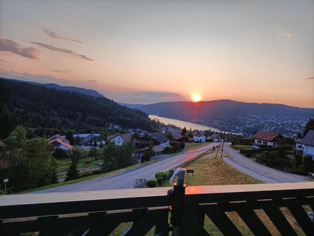 una persona che scatta una foto al tramonto di Appartement GERARDMER - Magnifique vue sur le lac - jusqu'à 4 personnes a Gérardmer