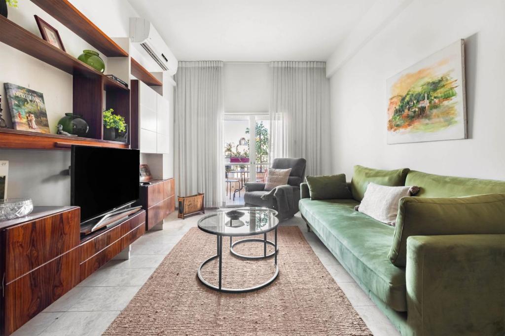 a living room with a green couch and a table at Ben Yehuda Elegant City Retreat with Shelter by Sea N Rent in Tel Aviv