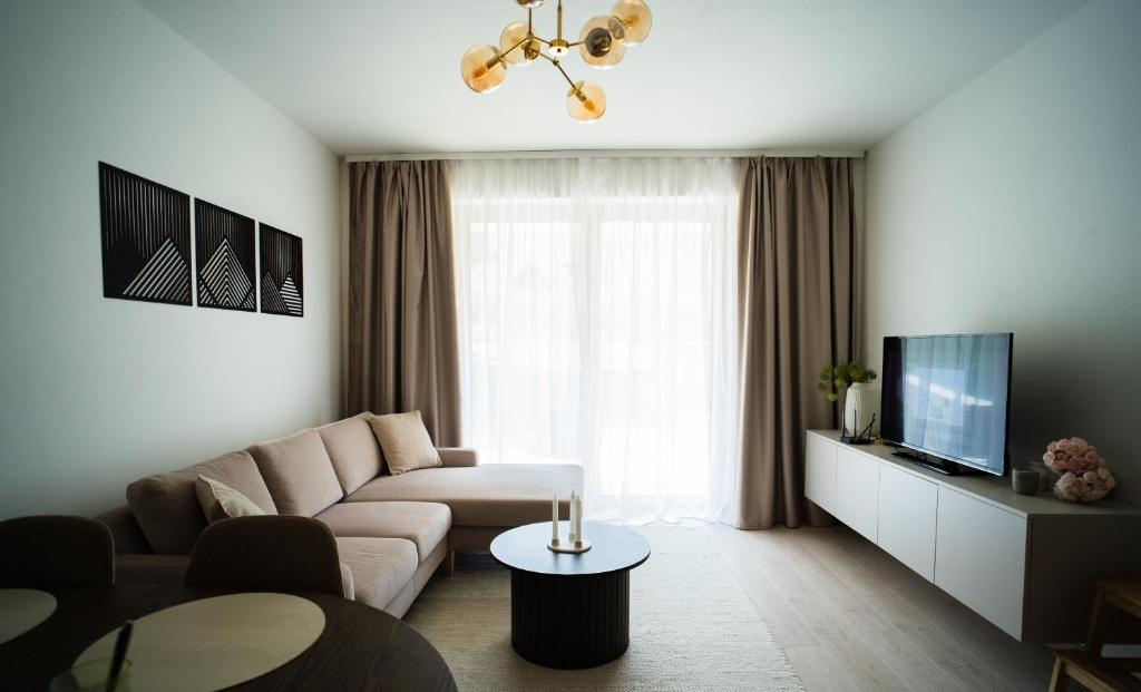 a living room with a couch and a tv at Apartmán Urban in Čierny Blh