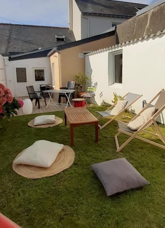 d'une cour avec des chaises, une table et une terrasse. dans l'établissement Jolie maison de pêcheur en bord de mer, à Port-Louis