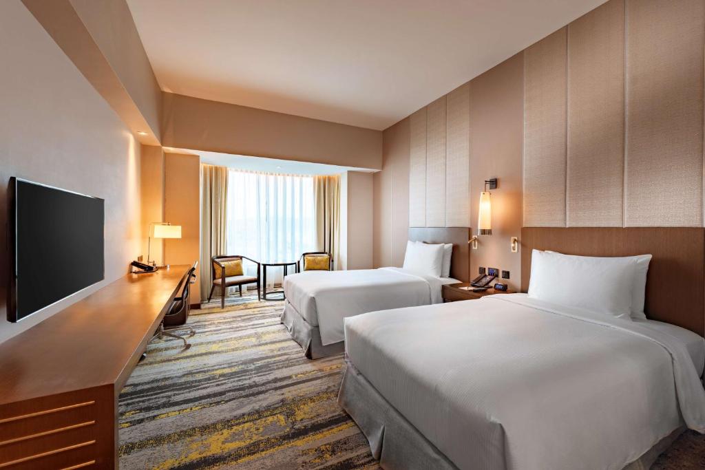 Postel nebo postele na pokoji v ubytování Hilton Kota Kinabalu