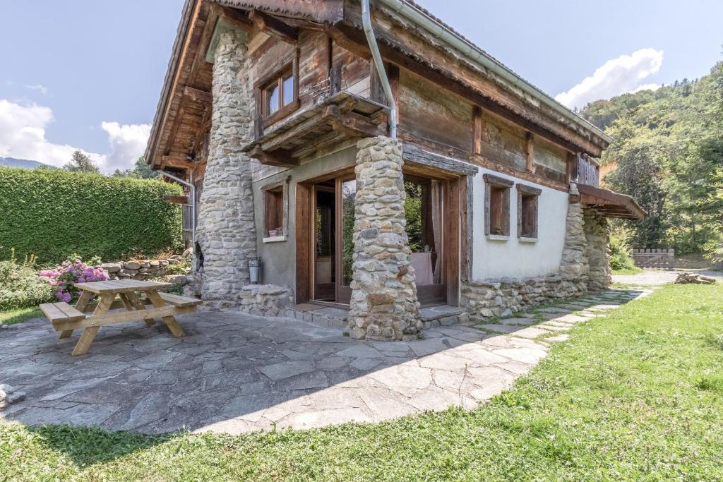 une maison en pierre avec une table de pique-nique devant elle dans l'établissement Le Gite - L'oréade - 6 pax, à Saint-Gervais-les-Bains