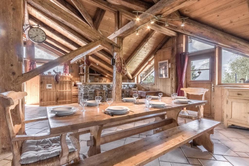 une salle à manger avec une grande table et des chaises en bois dans l'établissement Le Gite - Le Mont Blanc - 9 pax, à Saint-Gervais-les-Bains