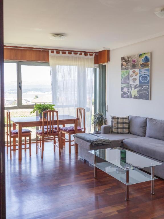 a living room with a couch and a table at BaruHaus piscina y parking Rianxo 1 in Rianjo