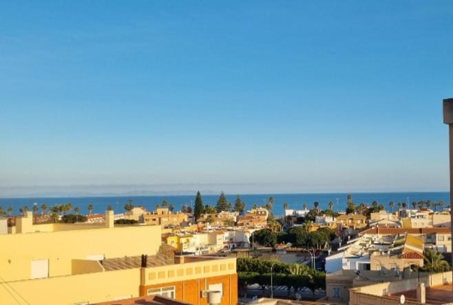 Eine Stadt mit Gebäuden und dem Meer im Hintergrund in der Unterkunft Torete in Roquetas de Mar