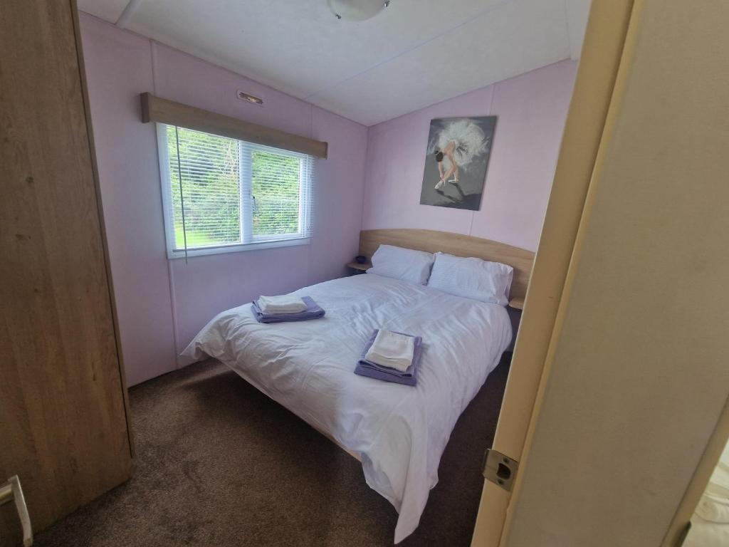 Un dormitorio con una cama con dos toallas encima. en Lodge Sleeps 4 - Pet Friendly with Private Parking, en Barnstaple