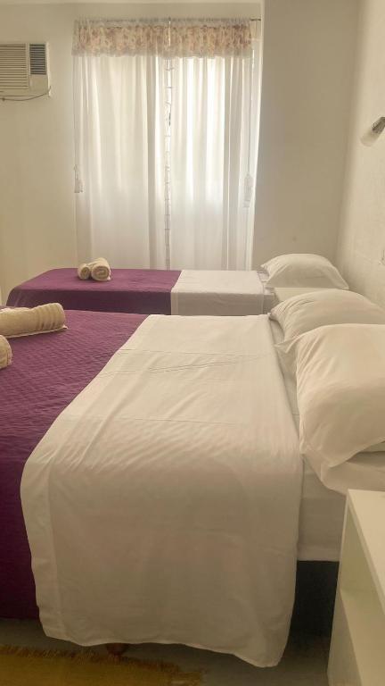 dwa łóżka pojedyncze w pokoju z oknem w obiekcie Hotel Residencial Marlis w mieście Posadas
