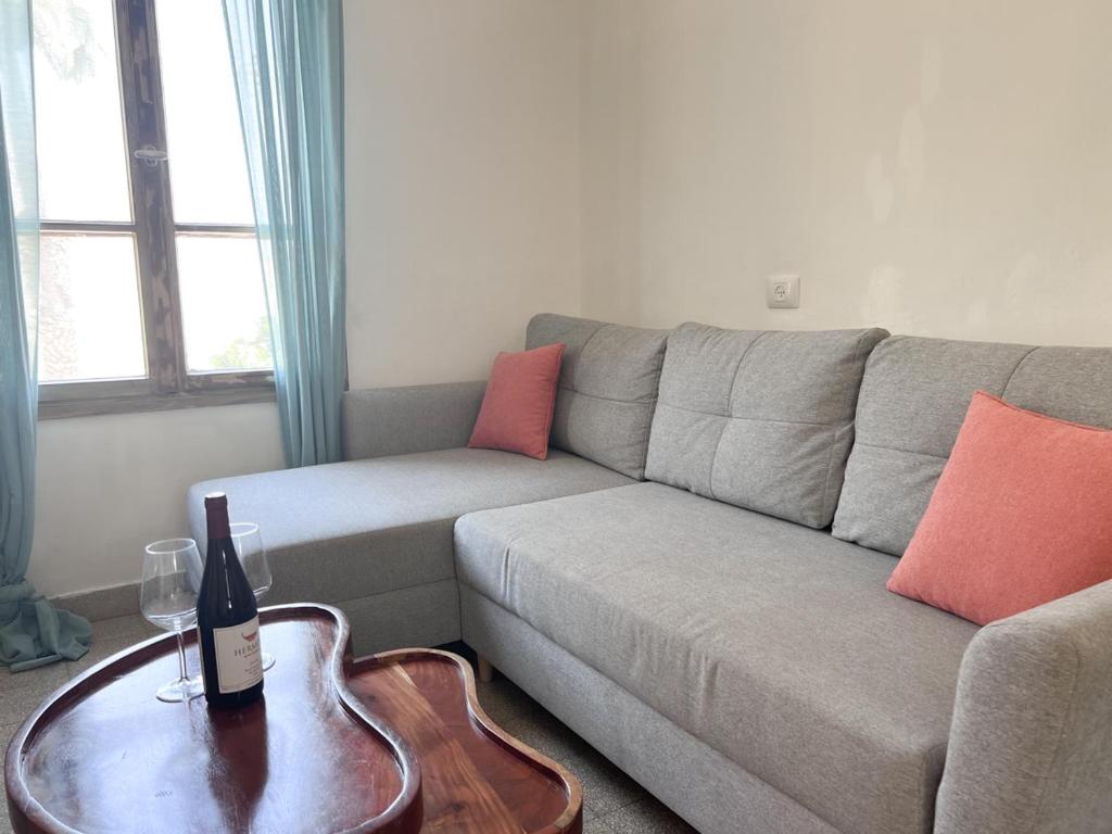 a living room with a couch and a table with a guitar at הצימר של יהושע in Ein Gedi