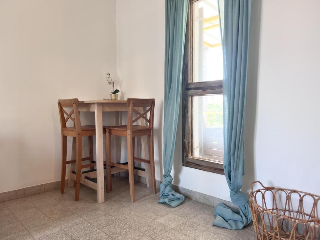 a table and chairs in a room with a window at הצימר של יהושע in Ein Gedi