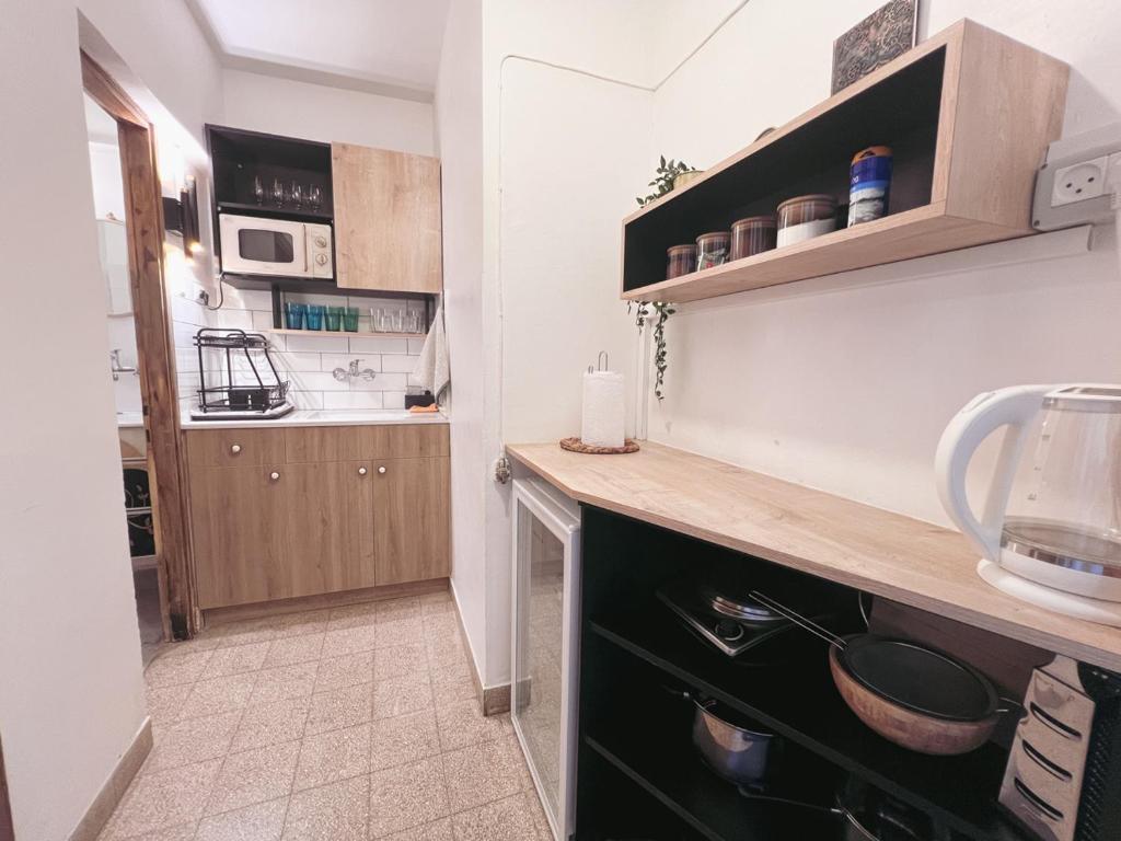 a kitchen with wooden cabinets and a counter top at הצימר של יהושע in Ein Gedi
