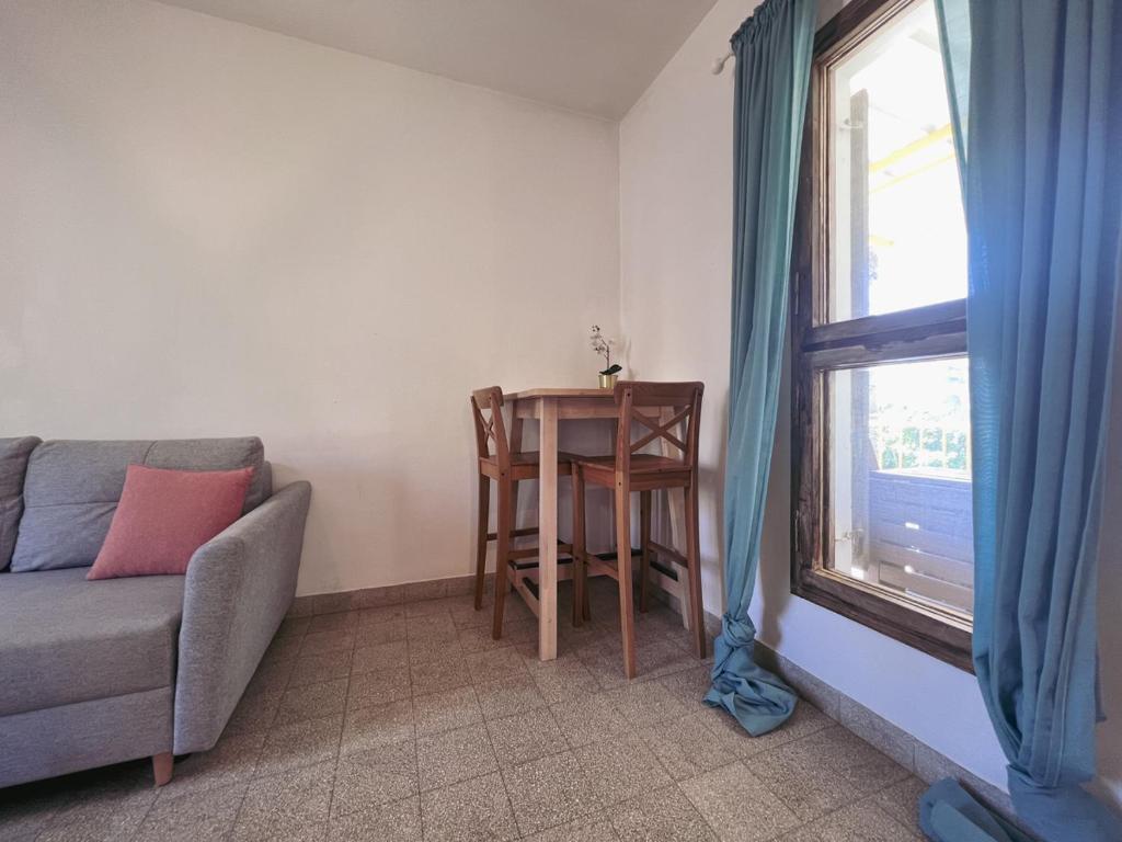 a living room with a table and a couch and a window at הצימר של יהושע in Ein Gedi