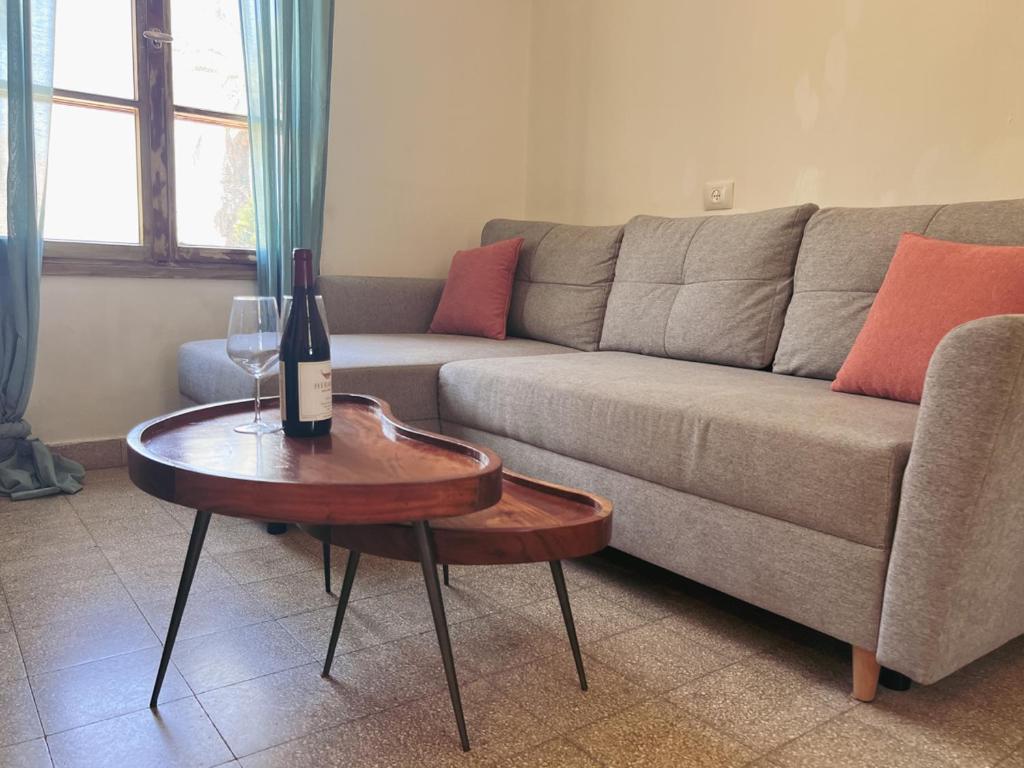 a living room with a couch and a wine bottle on a table at הצימר של יהושע in Ein Gedi