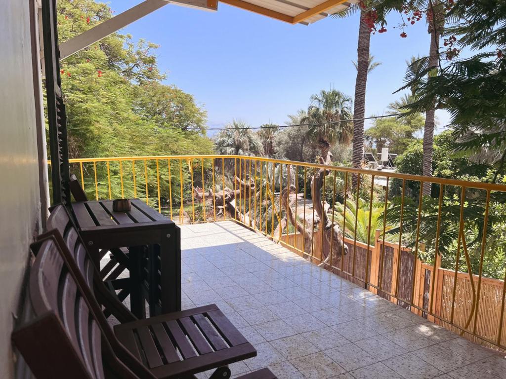 a porch with a bench and a view of a zoo at הצימר של יהושע in Ein Gedi