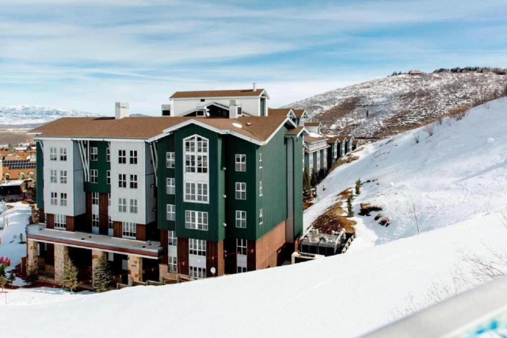 a green and white building in the snow at Marriott Mountainside 2BD in Park City