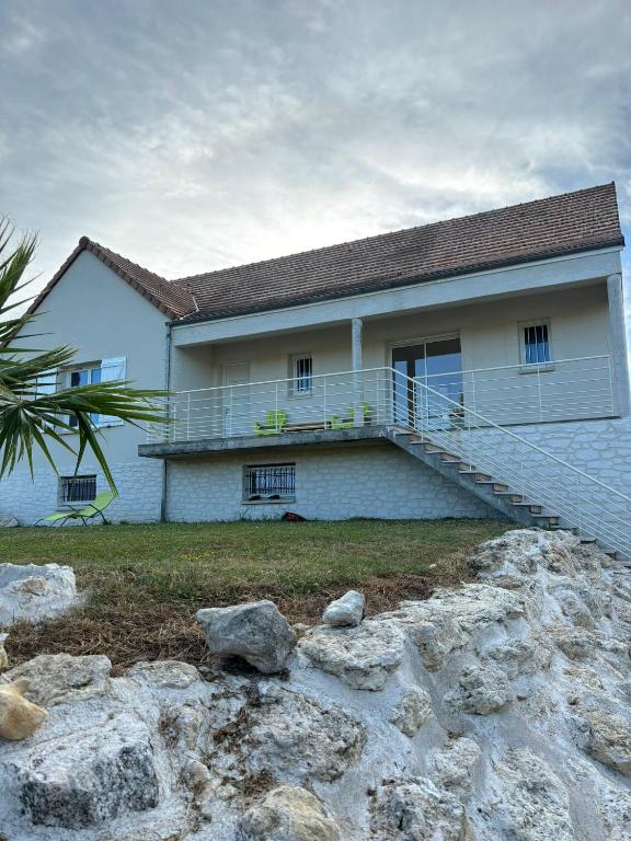 une maison blanche avec un escalier en face de celle-ci dans l'établissement La maison des Oliviers, 5min du ZooParc de Beauval, à Saint-Aignan