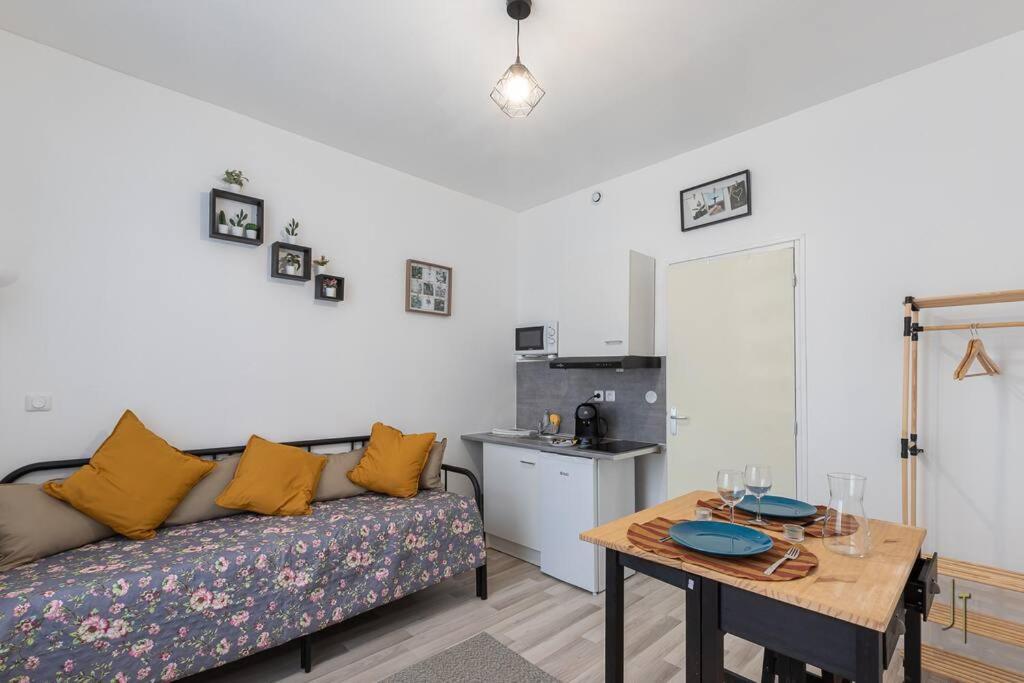 un salon avec un canapé et une table dans l'établissement Super Studio Bien équipé, à Saint-Quentin