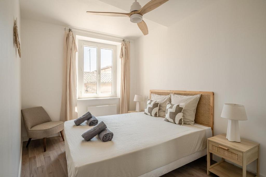 une chambre blanche avec un lit et une fenêtre dans l'établissement OIQIA • Olympe, à Narbonne