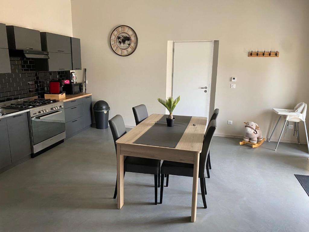 une table à manger avec des chaises et une horloge murale dans l'établissement Type t3 Lancon de Provence, à Lançon-Provence