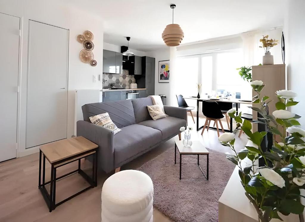 un salon avec un canapé et une table dans l'établissement L'Elégance Parisien, à Saint-Ouen