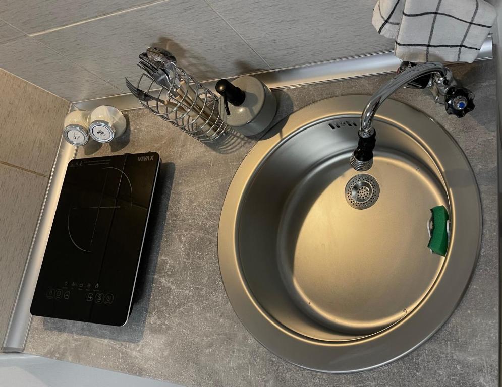un lavandino con un cellulare accanto di 'MONAS' mini apartments a Sombor