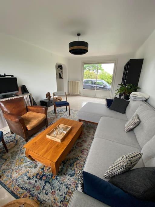 un salon avec un canapé et une table basse dans l'établissement Maison familiale La Moutonnière, à Prinquiau