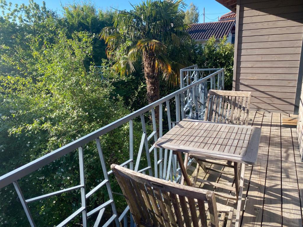 einen Holztisch und zwei Stühle auf einer Terrasse in der Unterkunft Maison 2ch, Parking, à 10min de Bx, Calme in Mérignac