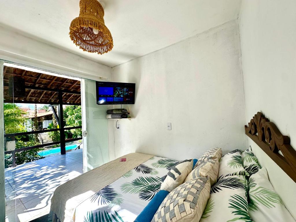 a bedroom with a bed and a tv on the wall at Suítes - Village Capixaba in Gravatá