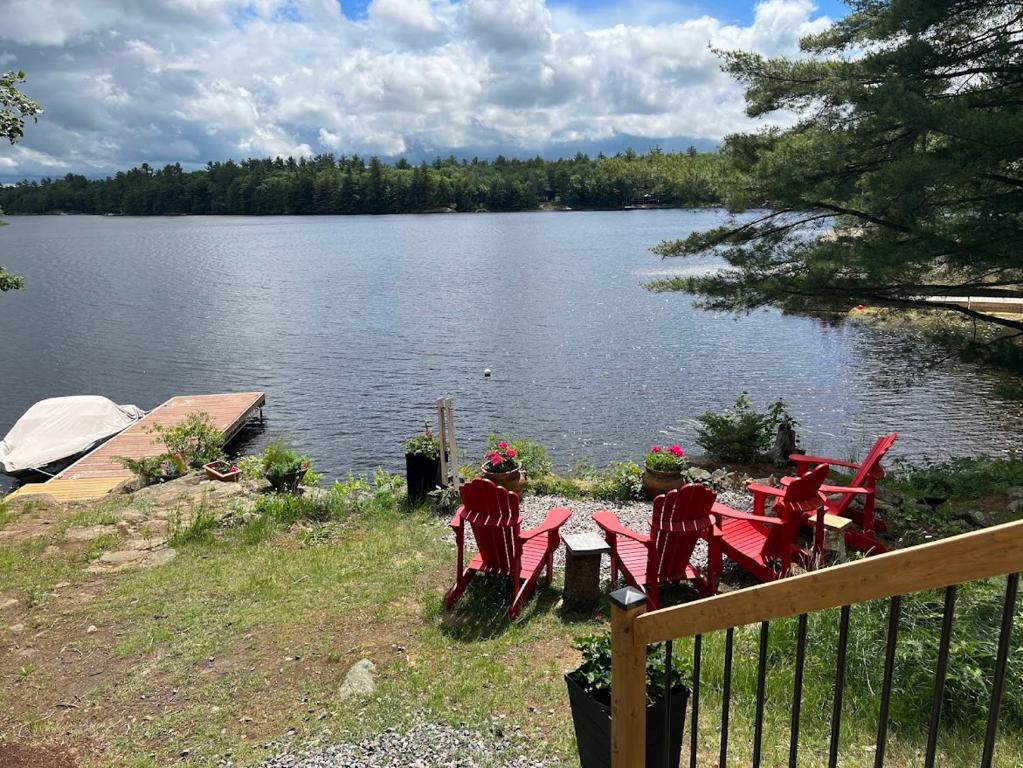 un tavolo con sedie rosse accanto a un lago di Davi's Lake House a Torrance