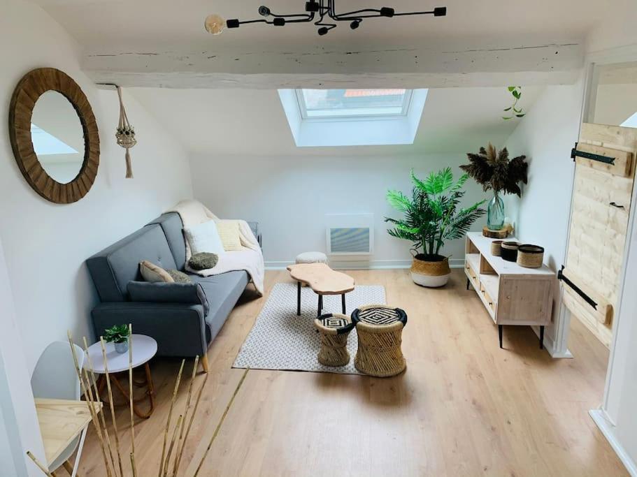 un salon avec un canapé bleu et une table dans l'établissement Appartement en centre-ville, à Remiremont