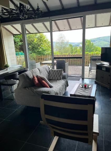 ein Wohnzimmer mit einer Couch und einem Tisch in der Unterkunft Le Vieux Sart 32 Coo in Stavelot