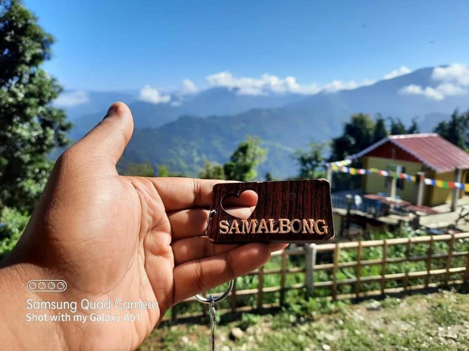 a hand holding a small container with the word sandwich at ATC Samalbong Paharer Bari in Kalimpong