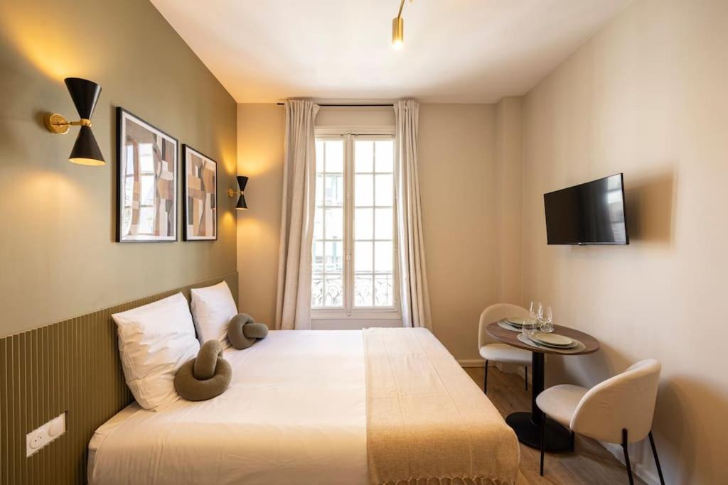une chambre avec un lit, une table et une télévision dans l'établissement Studio calme et paisible aux porte de Paris, à Le Pré-Saint-Gervais