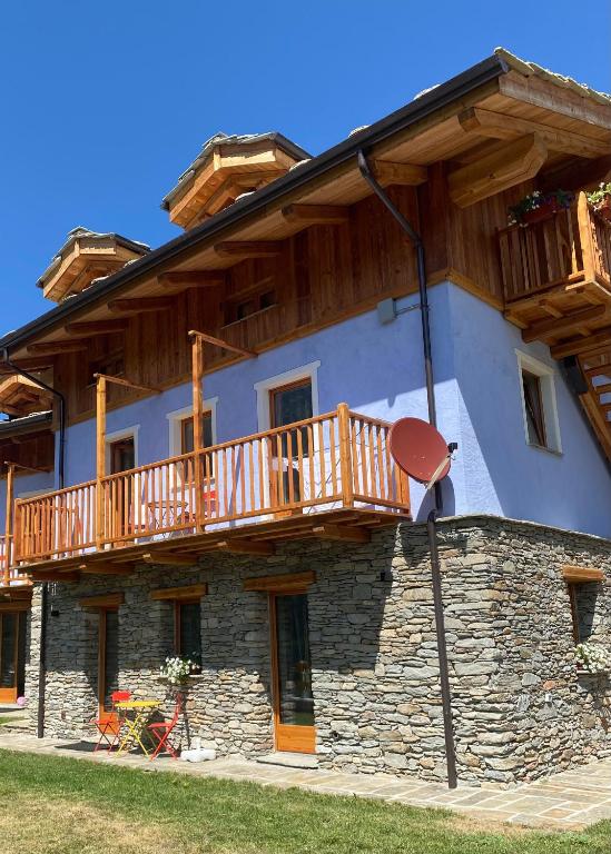 a large building with a wooden balcony on it at I tre corvi - Rocca Bianca in Prali